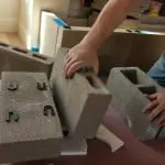 Installers installing fireplace mantel by Old World Stoneworks