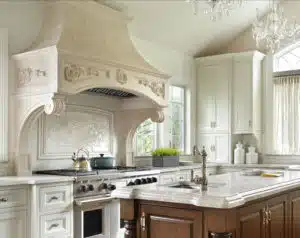 All-white Florentine cast stone range hood in a pristine kitchen.