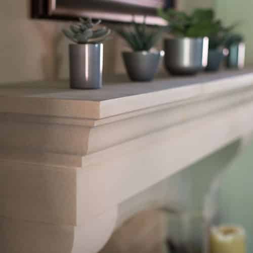 Close-up of Bowen cast stone fireplace mantel details in a home living room.