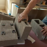 Installers installing fireplace mantel by Old World Stoneworks